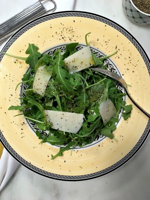 Top over arugula with fresh parmesan 