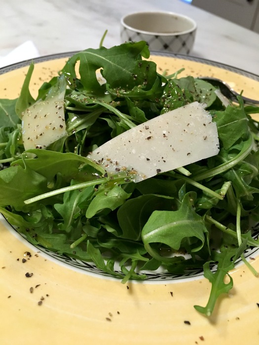 Top over arugula with fresh parmesan 